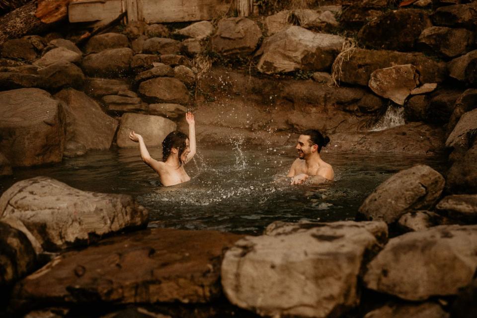 The couple is in a small body of water surrounded by rocks