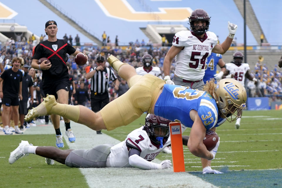 UCLA running back Carson Steele, center, falls short of a touchdown after being tripped up by North Carolina Central defensive back JaJuan Hudson, below, as linebacker Max U'Ren runs behind during the first half of an NCAA college football game Saturday, Sept. 16, 2023, in Pasadena, Calif. (AP Photo/Mark J. Terrill)