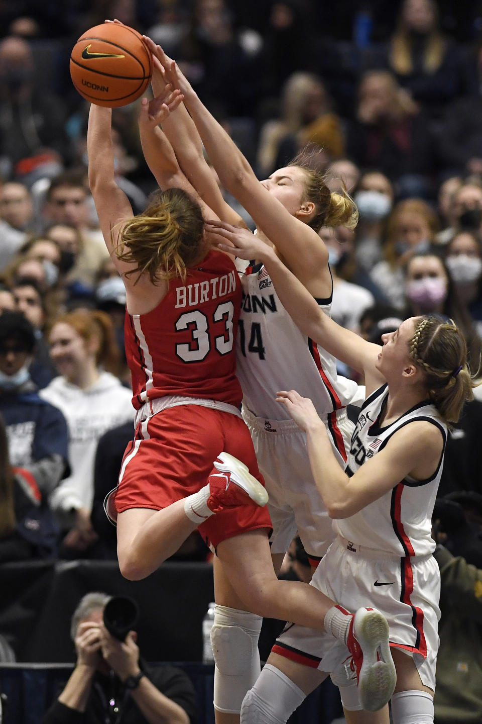 Connecticut's Dorka Juhasz, center, blocks a shot by St. John's Katie Burton (33) as Connecticut's Paige Bueckers defends during the second half of an NCAA college basketball game Friday, Feb. 25, 2022, in Hartford, Conn. (AP Photo/Jessica Hill)
