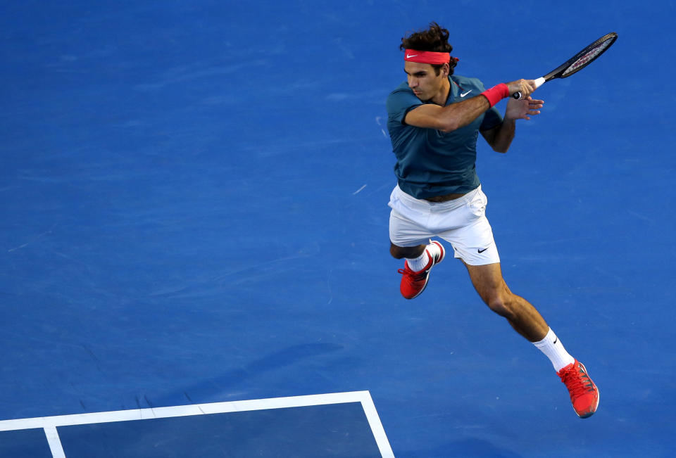 Roger Federer of Switzerland leaps for a shot to Andy Murray of Britain during their quarterfinal at the Australian Open tennis championship in Melbourne, Australia, Wednesday, Jan. 22, 2014. (AP Photo/Eugene Hoshiko)