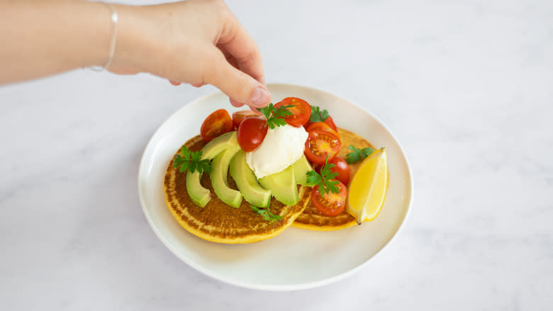 pancakes being garnished with parsley 