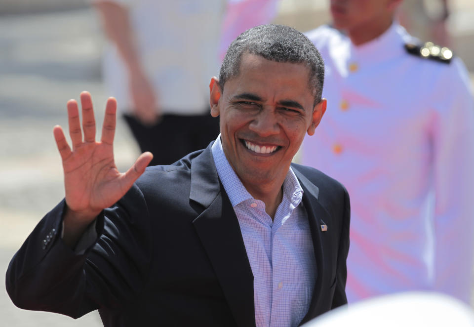 President Barack Obama waves as he arrives at the Convention Center for the second working session of the sixth Summit of the Americas in Cartagena, Colombia, Sunday April 15, 2012. (AP Photo/Fernando Llano)