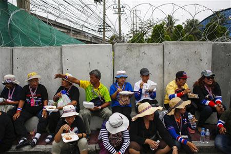 Anti-government protesters eat lunch near a barricade during a rally inside a compound of the Thai Royal Police Club in Bangkok February 21, 2014. REUTERS/Athit Perawongmetha