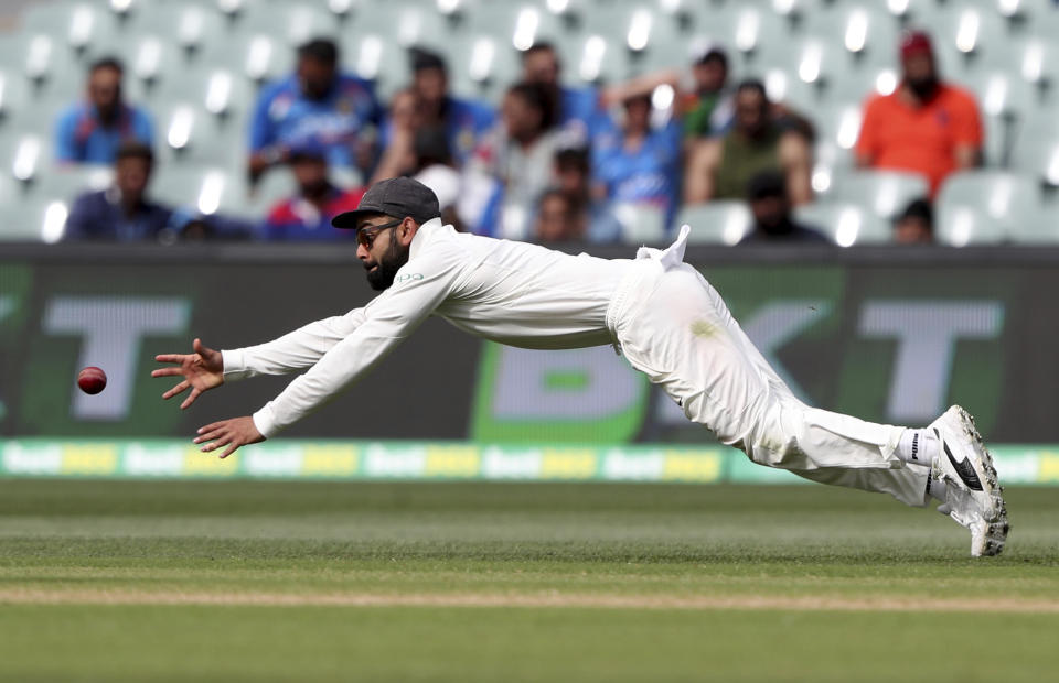 India's Virat Kohli dives to filed the ball during the first cricket test between Australia and India in Adelaide, Australia,Sunday, Dec. 9, 2018. (AP Photo/James Elsby)