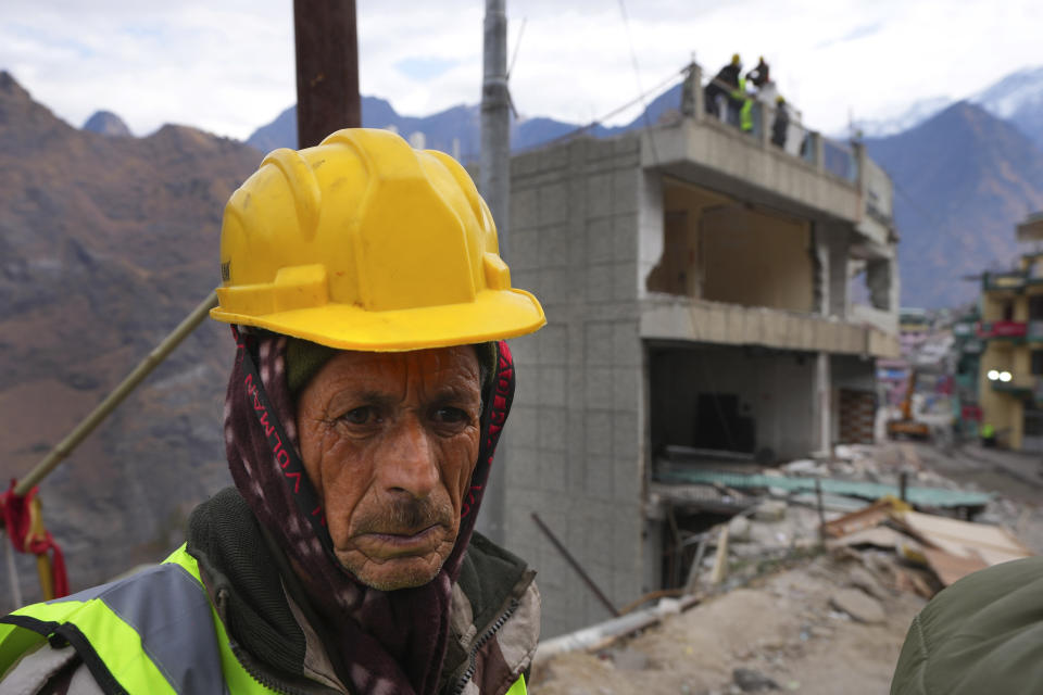 A laborer takes a break in between demolition of a residential building which has developed cracks in Joshimath, in India's Himalayan mountain state of Uttarakhand, Jan. 19, 2023. Big, deep cracks had emerged in over 860 homes in Joshimath, where they snaked through floors, ceilings and walls, making them unlivable. Roads were split with crevices and multi-storied hotels slumped to one side. Authorities declared it a disaster zone and came in on bulldozers, razing down whole parts of a town that had become lopsided. (AP Photo/Rajesh Kumar Singh)