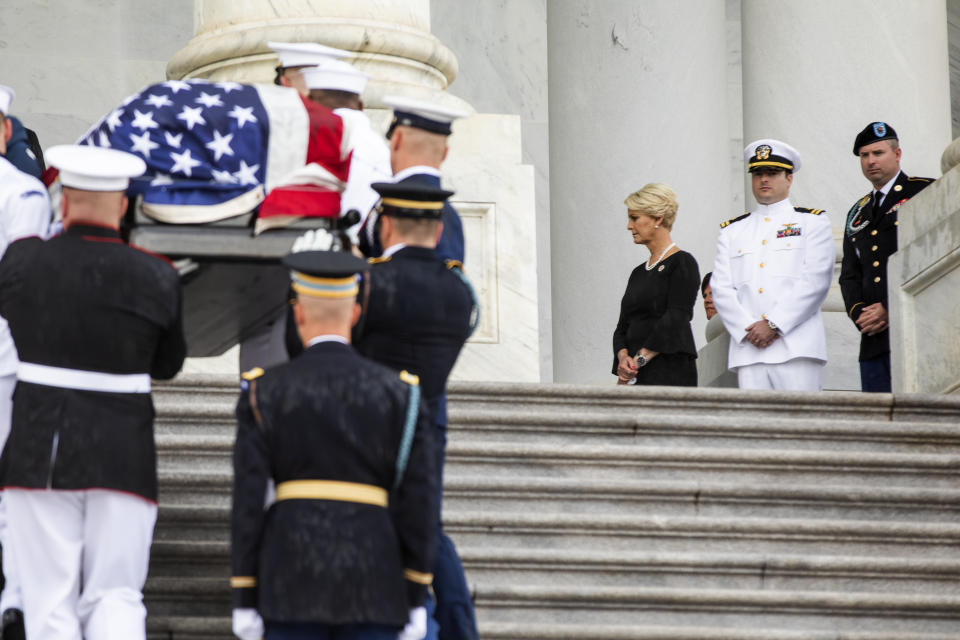 The flag-draped casket of Sen. John McCain, R-Ariz., is carried up the steps of the U.S. Capitol, Friday, Aug. 31, 2018, in Washington as Cindy McCain, top right, joined by her sons Jack McCain, and Jimmy McCain, right, watch. (Jim Lo Scalzo/Pool Photo via AP)