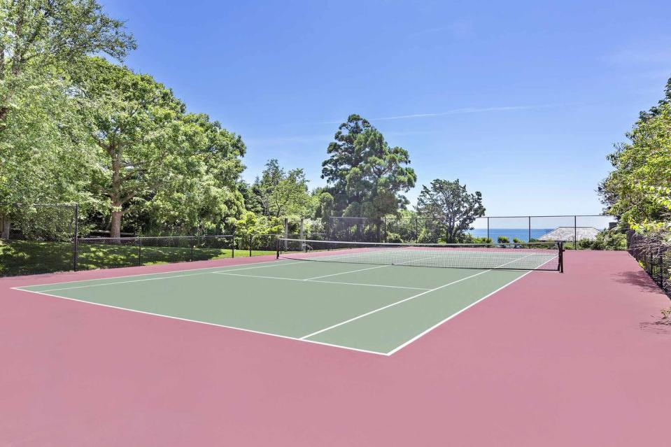 The grounds include a one-bedroom guest house, a pool, and this tennis court.