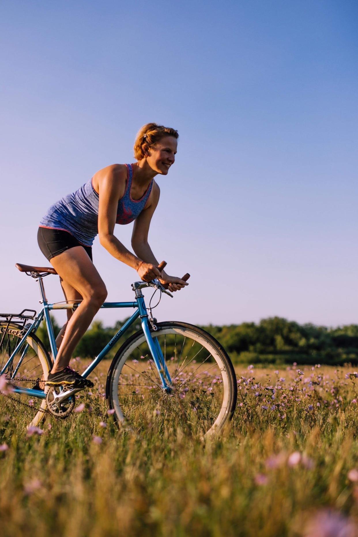 Kate Strong cycling through a field