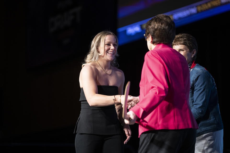No. 1 overall draft pick Sarah Fillier, left, who was drafted by New York, shakes hands with tennis great Billie Jean King, front right, during the PWHL hockey draft in St. Paul, Minn., Monday June, 10, 2024. (Renée Jones Schneider/Star Tribune via AP)
