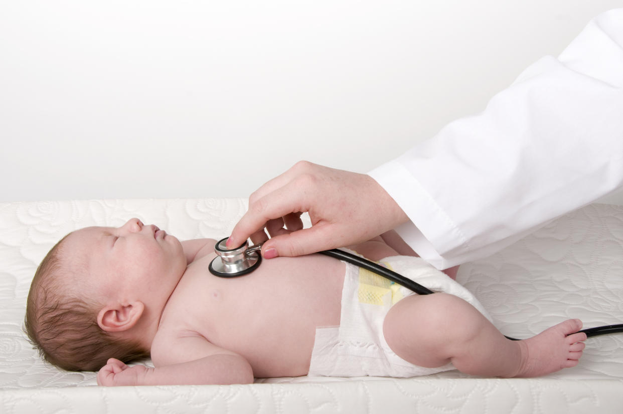 Medical doctor checking the heart rate of an unresponsive infant with a stethoscope.View Similar Images: