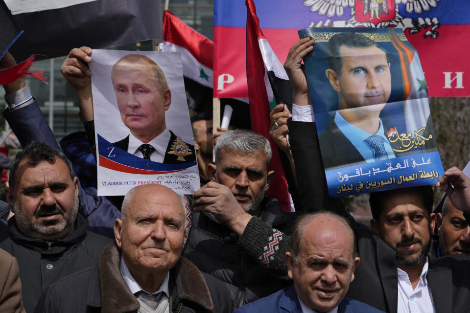 People hold portraits of Russian President Vladimir Putin, left, and Syrian President Bashar Assad, right, during a demonstration in support of Russia's invasion of Ukraine, in front of the U.N. headquarters in Beirut, Lebanon, Sunday, March 20, 2022. Dozens of Lebanese, Syrians and Russians gathered to support Putin whose military joined Syria's civil war in 2015 helping tip the balance of power in favor of President Bashar Assad's forces. (AP Photo/Bilal Hussein)