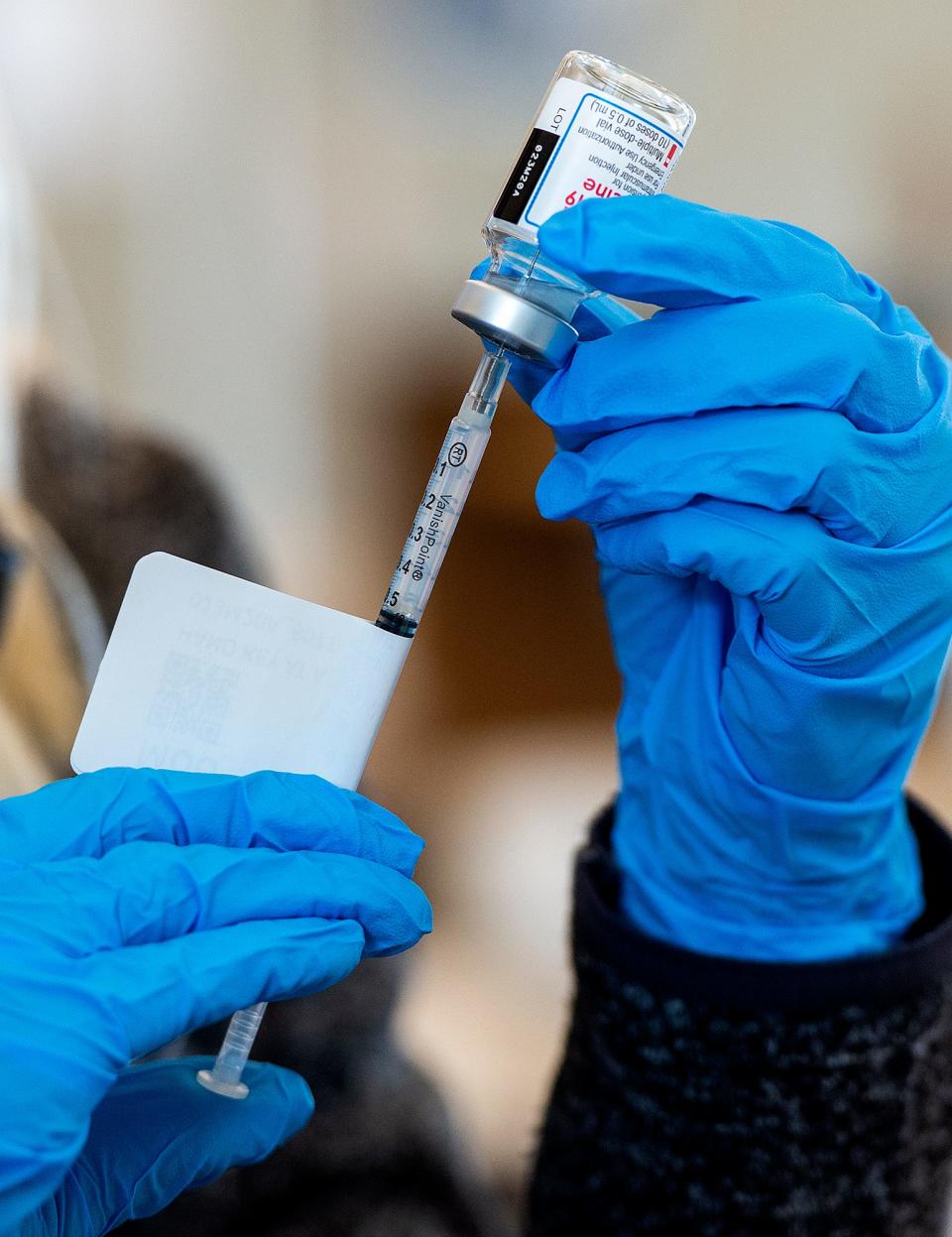 An AMI employee prepares one of the Moderna COVID-19 vaccines, at the Lower Bucks Campus of the Bucks County Community College in Bristol Township, on Tuesday, Feb. 16, 2021.