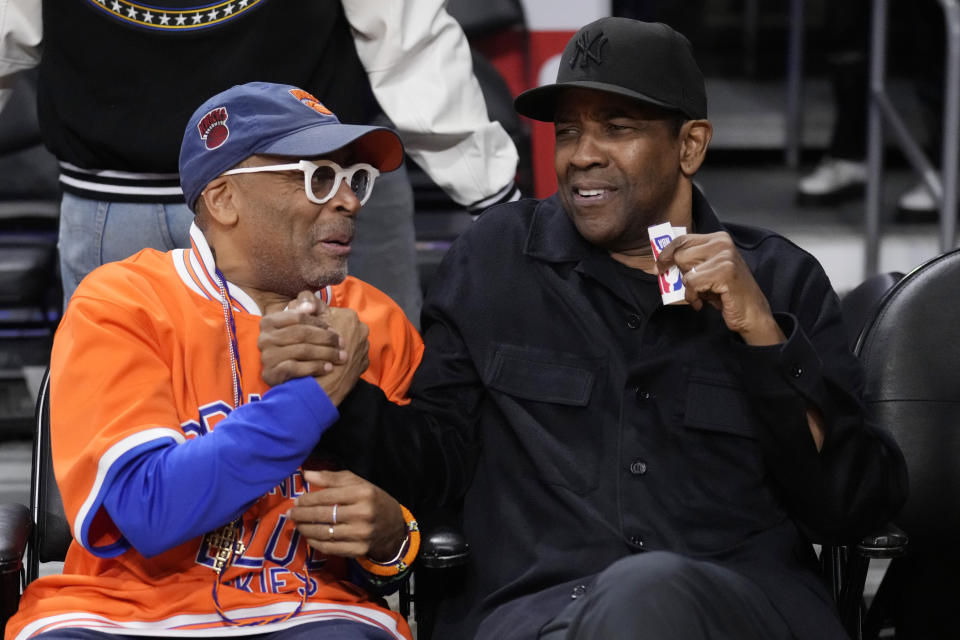 Actor Denzel Washington, right, shakes hands with director Spike Lee before an NBA basketball game between the Los Angeles Lakers and the New York Knicks Sunday, March 12, 2023, in Los Angeles. (AP Photo/Marcio Jose Sanchez)