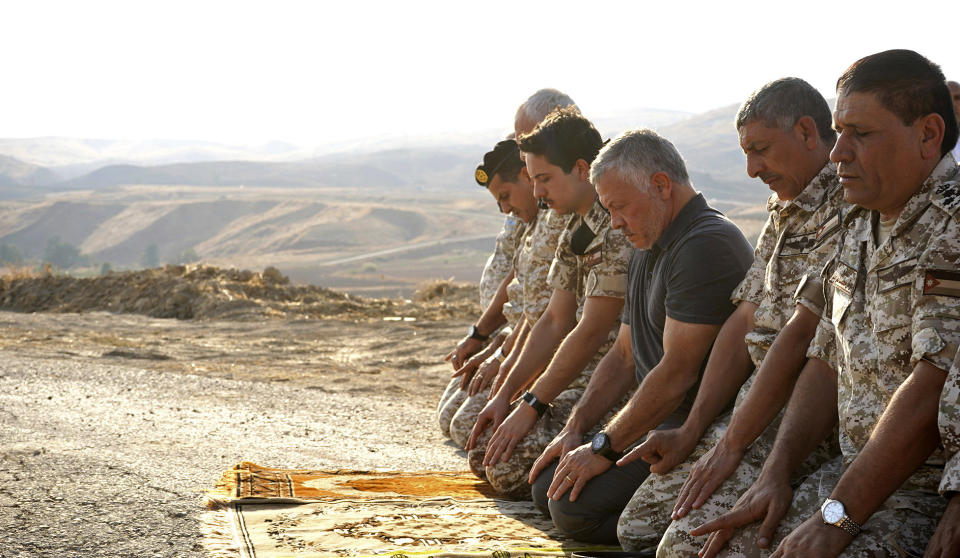 Jordan’s King Abdullah II, third right, prays during a tour of the Baqura enclave formerly leased by Israel, with Crown Prince Hussein, fourth right, and military officers, Monday, Nov. 11, 2019. Jordan’s decision not to renew the leases on the Baqura and Ghamr enclaves, known in Hebrew as Naharayim and Tzofar, were a fresh blow to Israel and Jordan’s rocky relations 25 years after the two countries signed a peace deal. (Yousef Allan/Jordanian Royal Court via AP)