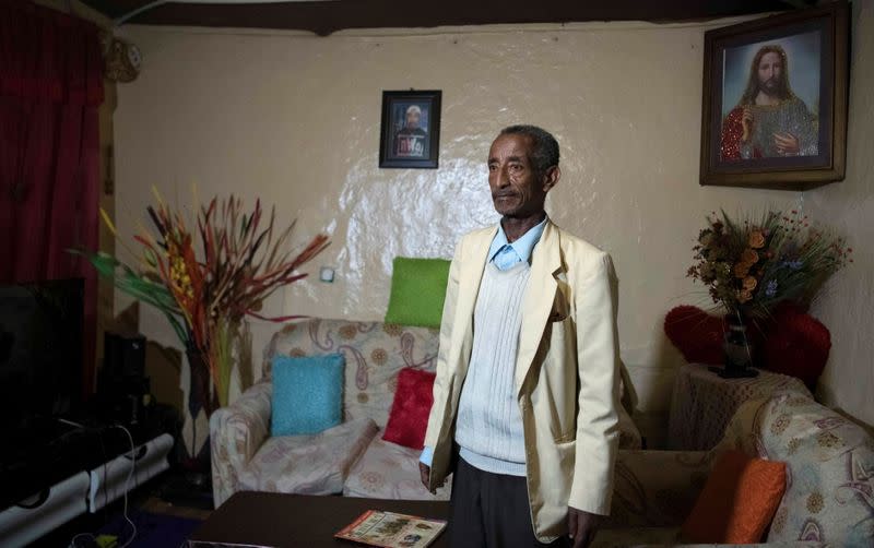 Ayalew Wedajo poses for a photograph inside his house during an interview with Reuters in Addis Ababa