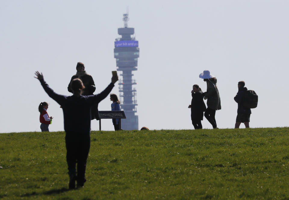 Pedestrians walk on Primrose Hill with the Post Office Tower as a backdrop in London, Monday, March 23, 2020. The British government is encouraging people to practice social distancing to help prohibit the spread of Coronavirus, further restrictions may be imposed if the public do not adhere to their advice. For most people, the new coronavirus causes only mild or moderate symptoms, such as fever and cough. For some, especially older adults and people with existing health problems, it can cause more severe illness, including pneumonia. (AP Photo/Frank Augstein)