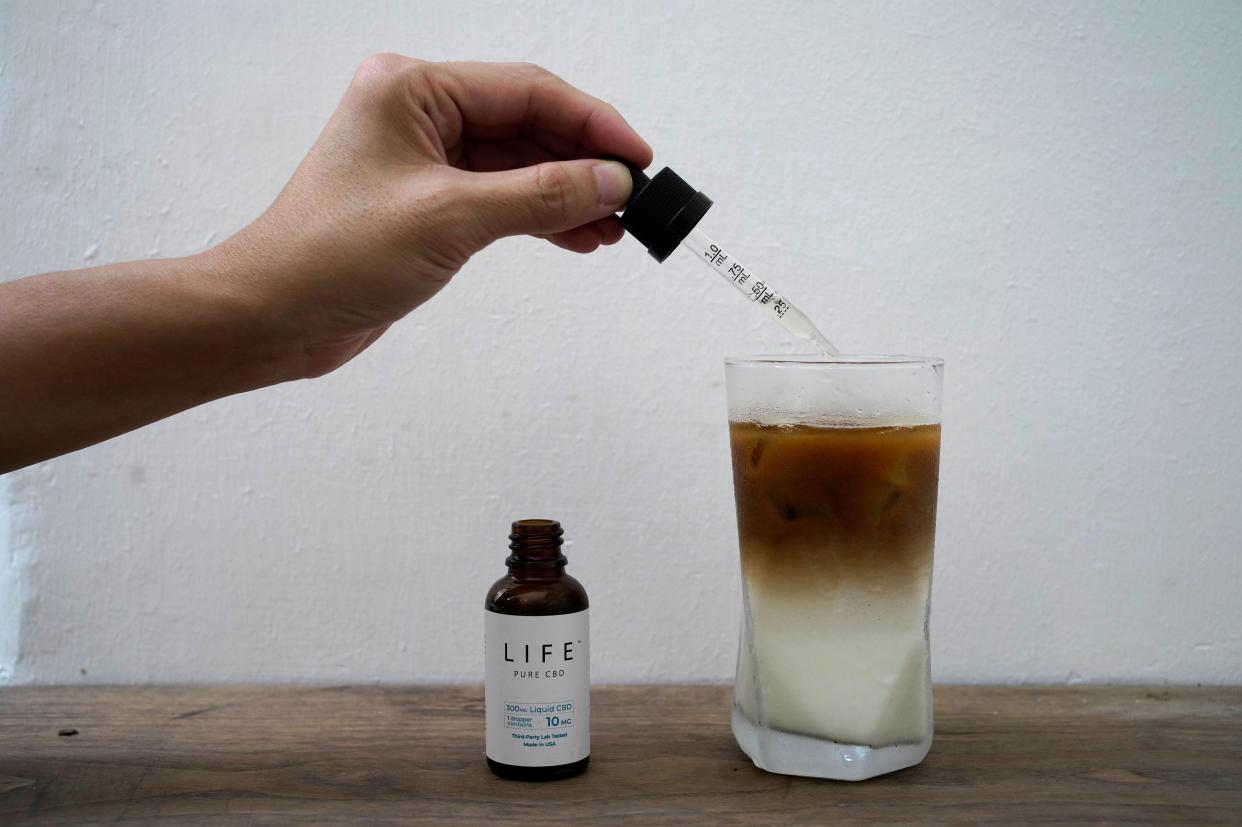 An employee adds drops of water-soluble CBD, or cannabidiol, an essential component of medical marijuana, into a coffee glass at the Found Cafe in Hong Kong  (AP)