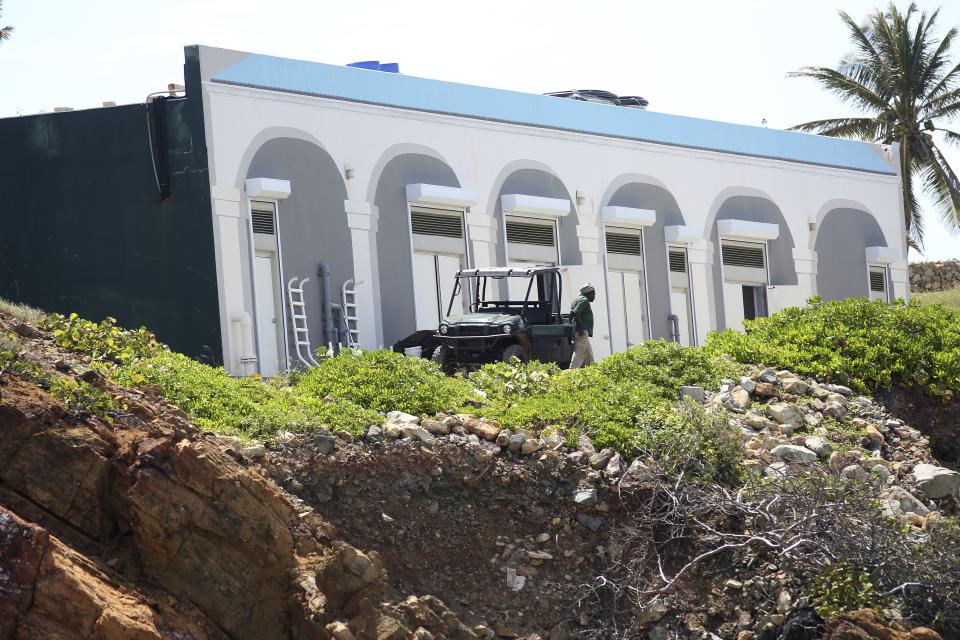 A man walks on Little St. James Island, in the U. S. Virgin Islands, a property owned by Jeffrey Epstein, Wednesday, Aug. 14, 2019. Jeffrey Epstein’s armed guards and the sharp rocks that lie beneath the turquoise waters glistening around his Caribbean island have long deterred boaters from the area, but curiosity has overcome concern ever since the financier apparently killed himself in jail as he awaited trial in New York on sex trafficking charges. (AP Photo/Gabriel Lopez Albarran)