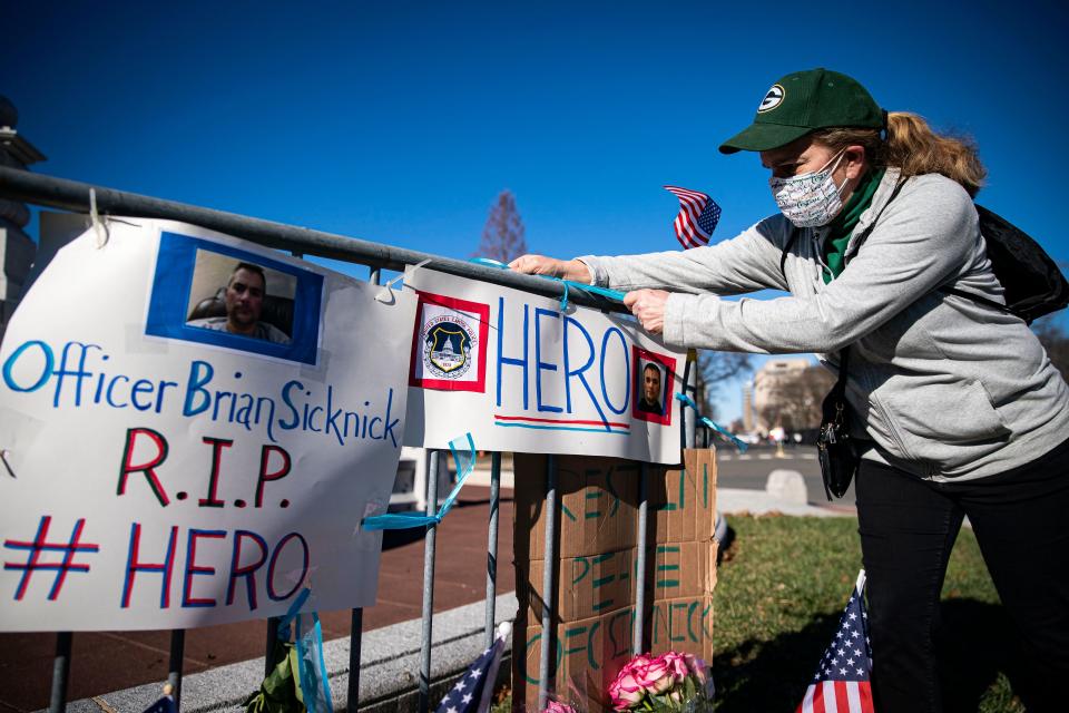 Anne Seymour, a crime victim advocate, creates a makeshift memorial Jan. 9 in Washington for U.S. Capitol Police officer Brian Sicknick, who was fatally injured when a pro-Trump mob stormed the Capitol.