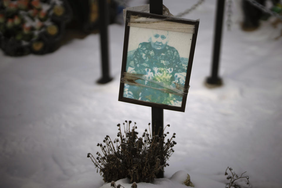 A faded portrait of Dina Pivin, 84, sits on her grave at a cemetery in Irpin, Ukraine, on the outskirts of Kyiv, on Thursday, Feb. 9, 2023. She died alone in her flat at age 84, afraid to leave and without food. After the block her apartment is on was shelled, the building manager grew concerned because he hadn’t heard from her. He asked one of the cleaners to check on her. The man arrived and found the key still lodged in Pivin’s door, and the woman lying on the ground. She was buried on March 16, 2022. (AP Photo/Emilio Morenatti)