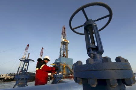 A worker checks an oil pipe at the Lukoil-owned Imilorskoye oil field outside the West Siberian city of Kogalym, Russia, in this January 25, 2016 file photo. REUTERS/Sergei Karpukhin