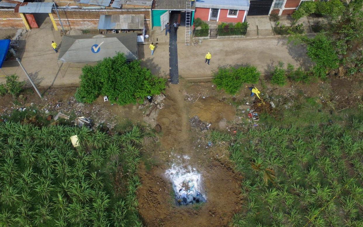 Forensic teams work to exhume several clandestine graves in Chalchuapa, El Salvador, Wednesday, May 19, 2021. The search at the home of a former policeman arrested last week for the murder of two women has turned up 10 other bodies, prosecutors said Friday, revealing the existence of a murder ring that allegedly killed as many as 13 people. - Salvador Melendez /AP