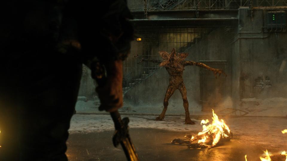 Hopper holding a weapon about to fight a Demogorgon.