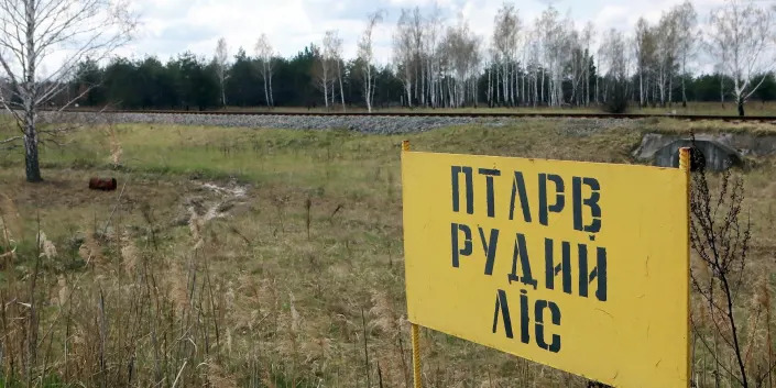 A yellow sign shows in Cyrillic indicates the limit of the red forest in Ukraine.