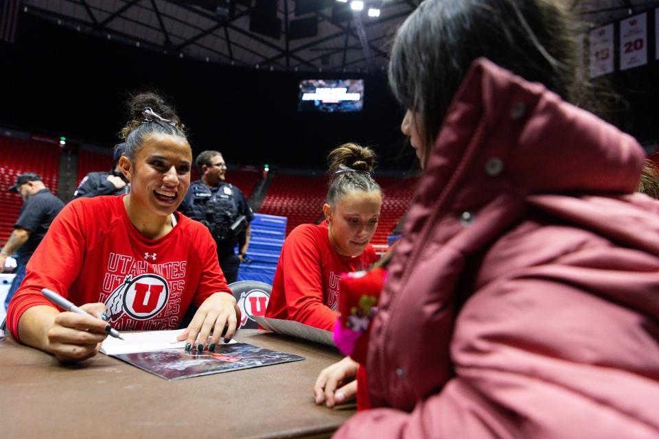 Amelie Morgan signs a poster after the Red Rocks Preview at the Jon M. Huntsman Center in Salt Lake City on Friday, Dec. 15, 2023. | Megan Nielsen, Deseret News