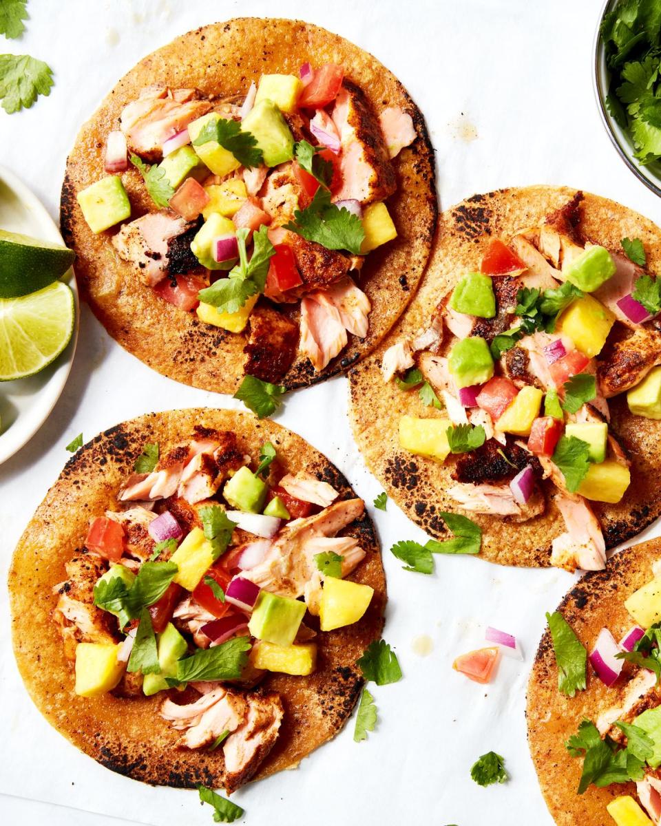 salmon tacos topped with mango salsa on a platter