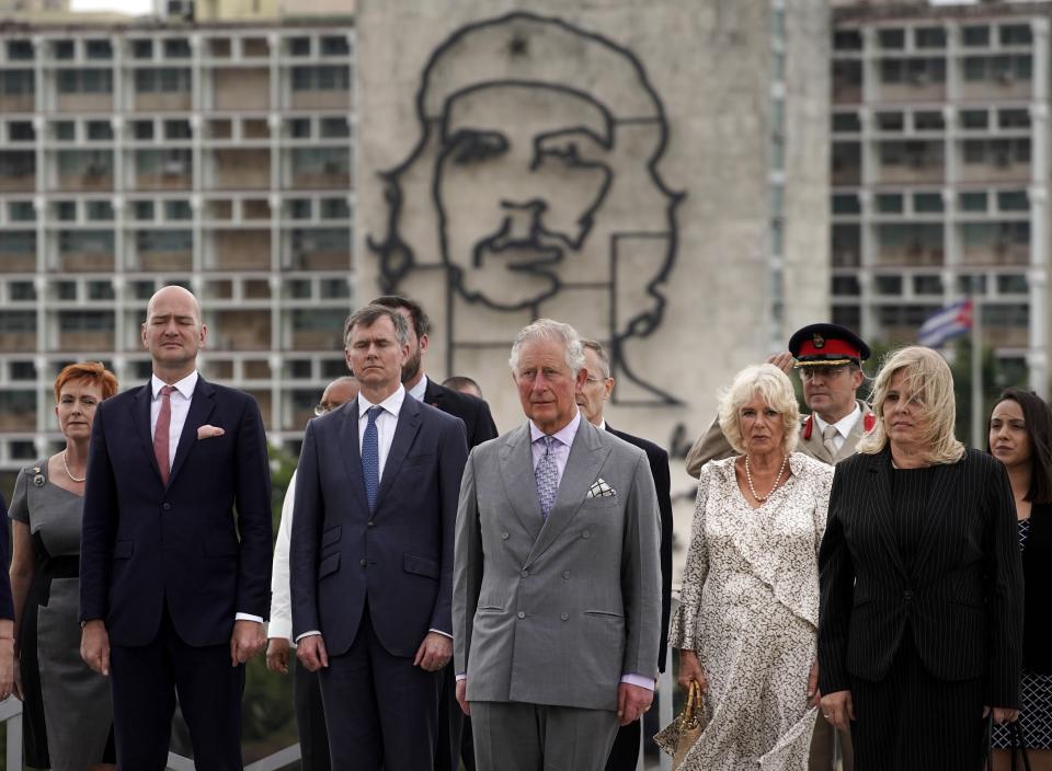 Backdropped by an image of Che Guevara, Britain's Prince Charles, the Prince of Wales, center, and Camilla, Duchess of Cornwall, center right, attend a wreath-laying ceremony at the Jose Marti Monument during their official visit in Havana, Cuba, Sunday, March 24, 2019. (AP Photo/Ramon Espinosa)