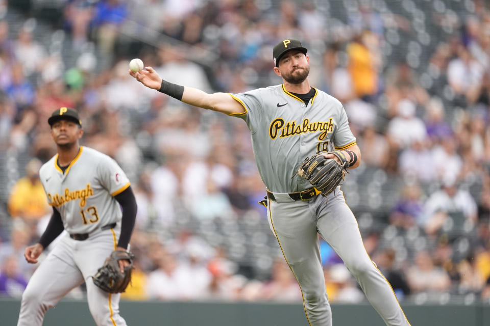 Pittsburgh Pirates shortstop Jared Triolo, right, throws to first base to put out Colorado Rockies' Jacob Stallings in the second inning of a baseball game Friday, June 14, 2024, in Denver. (AP Photo/David Zalubowski)