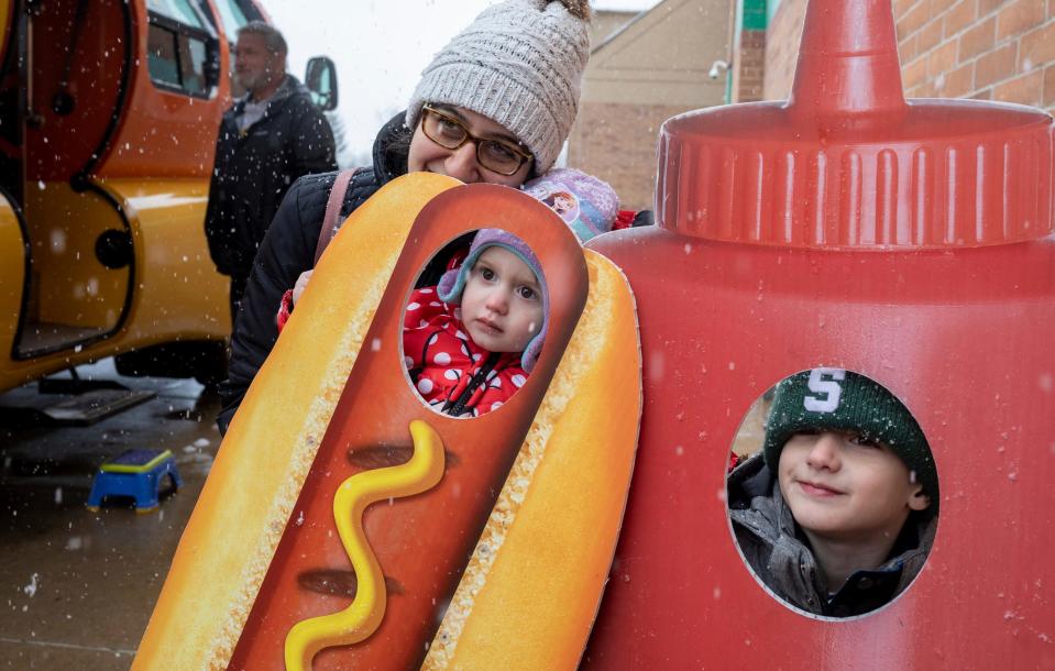 Bernadette Wenson, left, gets her photo taken with her children Bella Wenson, middle, and Blake Wenson, next to Oscar Mayer's Wienermobile during a snowy day in Shelby Township on Friday, March 22, 2024.