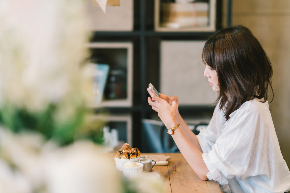 A young woman uses her smartphone.