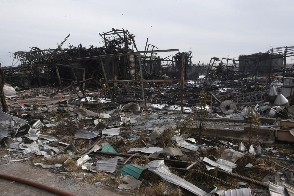 Twisted metal frames and debris are scattered on the site of a burnt chemical factory Tuesday, July 6, 2021 in Samut Prakan, Thailand. Firefighters finally extinguished a blaze at a chemical factory just outside the Thai capital early Tuesday, more than 24-hours after it started with an explosion that damaged nearby homes and then let off a clouds of toxic smoke that prompted a widespread evacuation. (AP Photo/Anuthep Cheysakron)