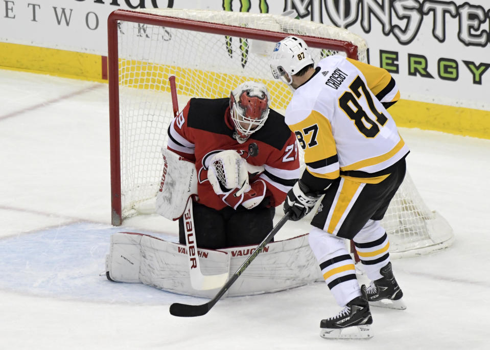 New Jersey Devils goaltender Mackenzie Blackwood (29) stops a shot by Pittsburgh Penguins center Sidney Crosby (87) during the first period of an NHL hockey game Friday, April 9, 2021, in Newark, N.J. (AP Photo/Bill Kostroun)