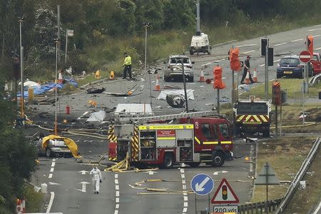 Emergency services and crash investigation officers work at the site where a Hawker Hunter fighter jet crashed onto the A27 road at Shoreham near Brighton, Britain August 23, 2015. REUTERS/Luke MacGregor