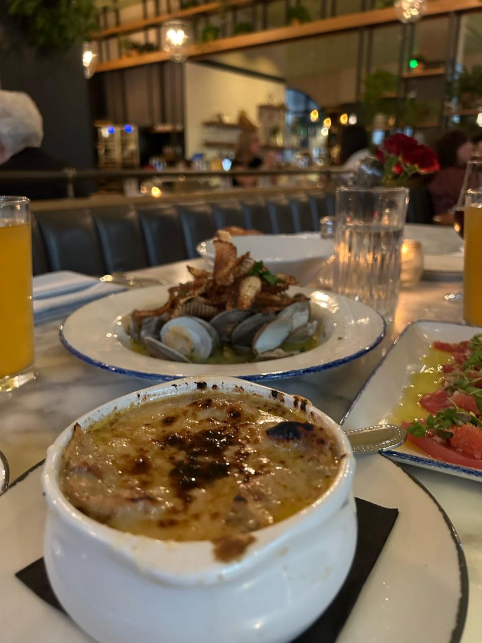 French Onion Soup, Tuna Crudo and Sapelo Clams grace a marble table to Emporium Kitchen and Wine Market.