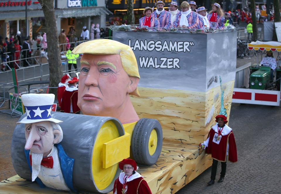 <p>Beim Kölner Karneval darf etwas Trump-Kritik ebenfalls nicht fehlen. Hier wird die USA als Dampfwalze dargestellt, die langsam aber sicher alles überrollt. „Langsamer Walzer“ steht auf dem Wagen geschrieben – der Kopf der Walze ist Trump, unter den Rädern liegt ein plattgedrückter Uncle Sam. (Bild: Oliver Berg/dpa) </p>