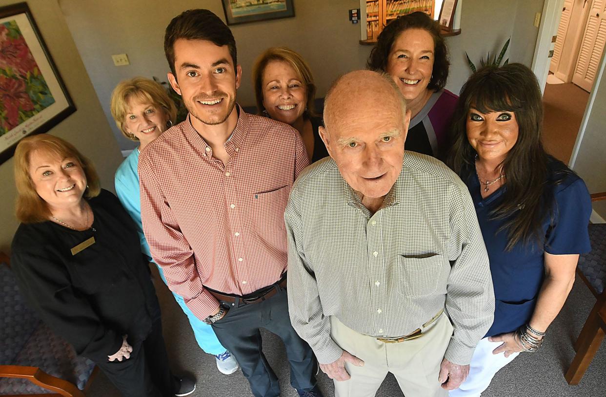 Dr. H.A. "Hal" Nicholson, surrounded by his staff, is retiring from his practice after 53 years. Dr. Lucas Fogaca (front left) will take over his practice.