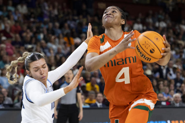 Miami's Jasmyne Roberts (4) drives to the basket against Villanova's Bella Runyan (32) in the second half of a Sweet 16 college basketball game at the NCAA Tournament in Greenville, S.C., Friday, March 24, 2023. (AP Photo/Mic Smith)