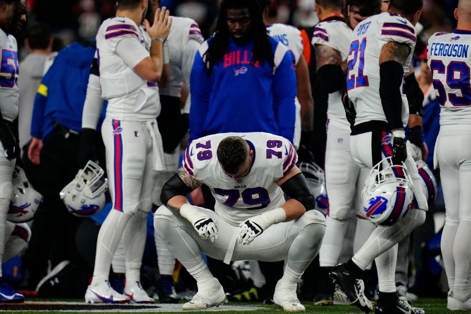 The Buffalo Bills gather as an ambulance parks on the field while CPR is administered to Buffalo Bills safety Damar Hamlin (3) after a play in the first quarter of the NFL Week 17 game between the Cincinnati Bengals and the Buffalo Bills at Paycor Stadium in Downtown Cincinnati on Monday, Jan. 2, 2023. The game was suspended with suspended in the first quarter after Buffalo Bills safety Damar Hamlin (3) was taken away in an ambulance following a play. 