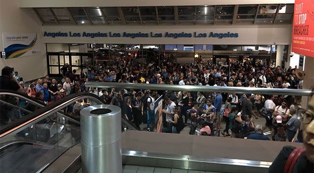 Stranded passengers wait while authorities conduct a sweep of the building. Photo: Twitter/Douglas Lee