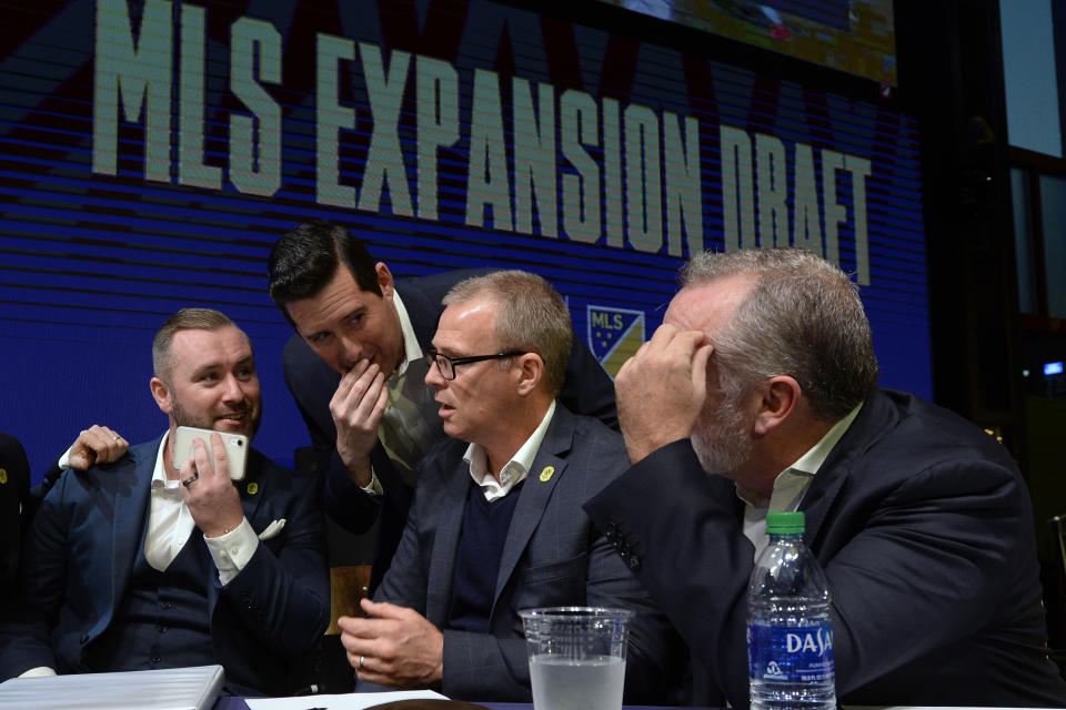 FILE - In this Nov. 19, 2019, file photo, from left, Nashville SC assistant general manager, Ally MacKay, general manager Mike Jacobs, head coach Gary Smith, and CEO Ian Ayre talk before making the team's first selection during the Major League Soccer expansion draft in Nashville, Tenn. Nashville SC opens their inaugural MLS season on Saturday. (AP Photo/Mark Zaleski, File)