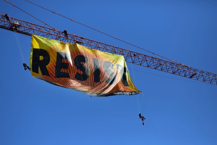 Greenpeace activists unfurl a banner from a construction crane near the White House