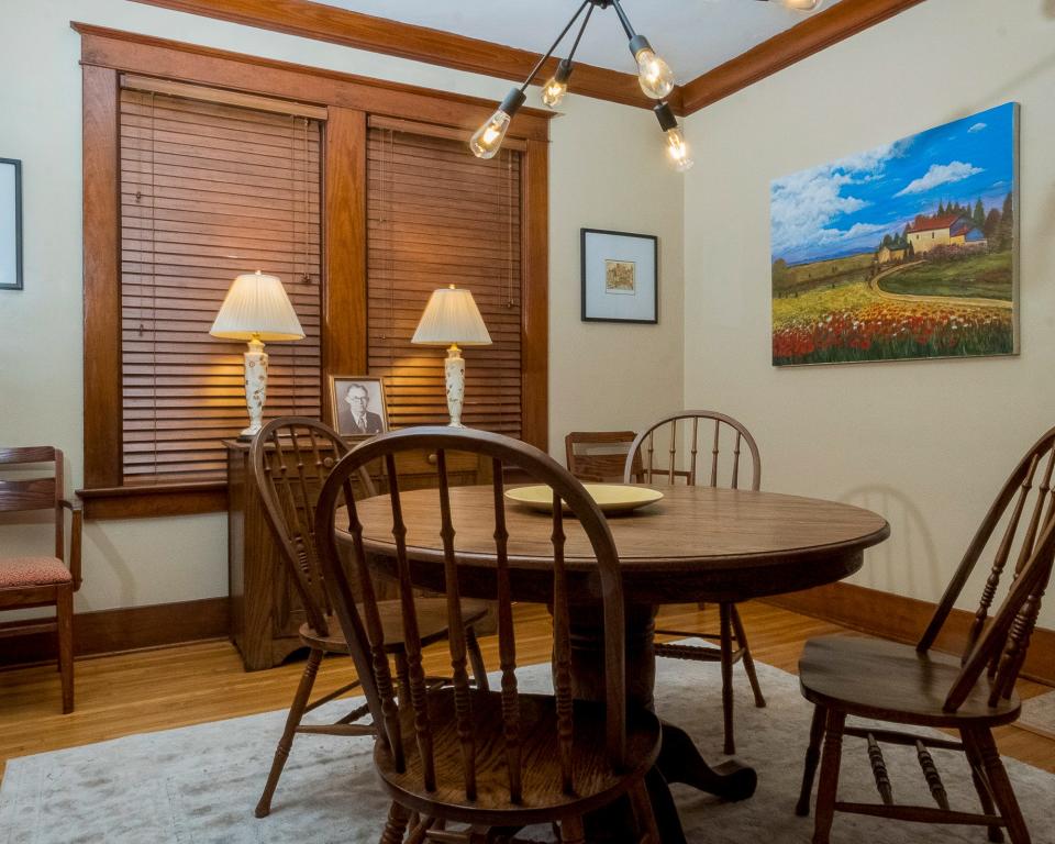The dining room uses colorful artwork to enhances the original woodwork.