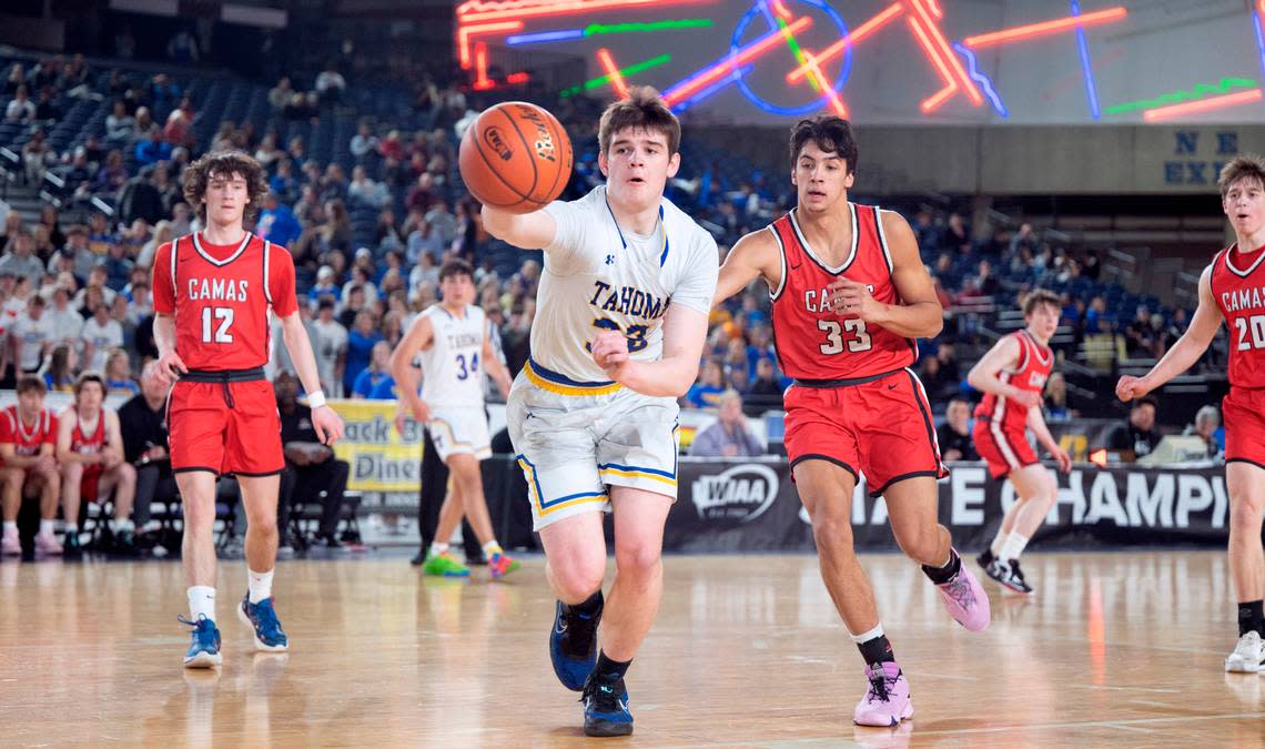 Tahoma’s Logan McGough chases down a loose ball in front of Camas defenders Jace VanVoorhis (12) and Jamison Carlisle during the opening day of the WIAA State Basketball tournament in the Tacoma Dome in Tacoma, Washington, on Wednesday, March 1, 2023. Camas won the game, 62-57.