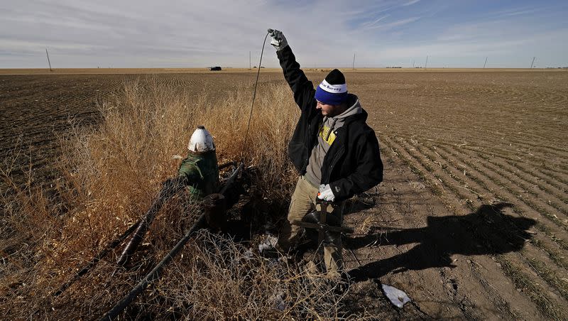 Kansas Geological Survey field research technician Connor Umbrell measures water levels in an irrigation well Thursday, Jan. 5, 2023, near Marienthal, Kan. The Earth’s axis has shifted eastward at an estimated rate of 1.7 inches every year due to a decade’s worth of consistent groundwater extraction and relocation, according to a recent study.