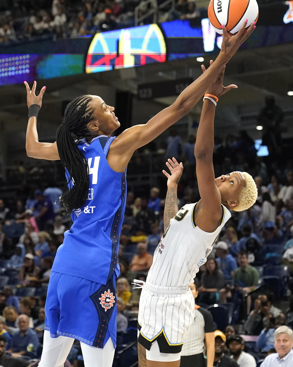 Connecticut Sun's DeWanna Bonner, left, and Chicago Sky's Courtney Williams battle for a rebound during the first half of a WNBA basketball game Wednesday, July 12, 2023, in Chicago. (AP Photo/Charles Rex Arbogast)