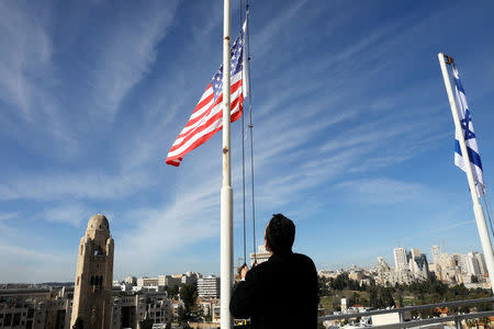 An employee of the King David Hotel raises the U.S. flag on the roof, ahead of the U.S. Vice President Mike Pence visit in Jerusalem January 21, 2018. REUTERS/Ronen Zvulun